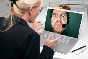 Shocked Woman In Kitchen Using Laptop with Grumpy Customer Support Man On Screen. Screen can be easily used for your own message or picture. Picture on screen is my copyright as well.